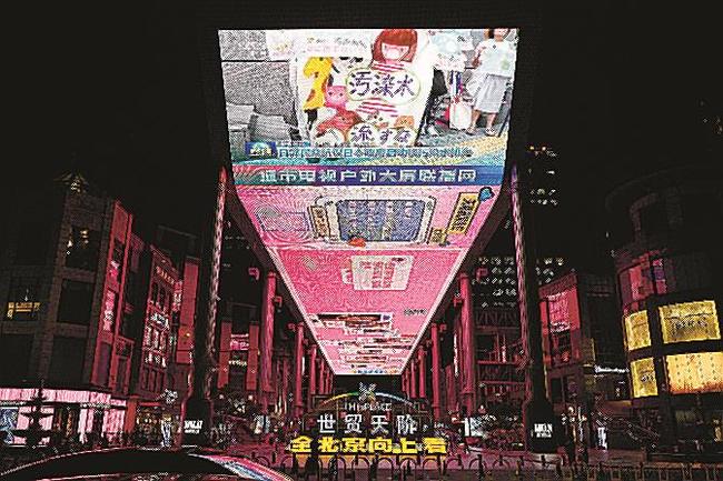 東京電力福島第１原発処理水の海洋放出が始まったニュースを映す北京市内の大型画面＝２４日（共同）