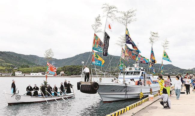 みこしを載せた船を先導するホーラエンヤの１１人（左）＝島根県海士町福井