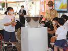 火を聖火皿に移す子どもたち＝倉吉市駄経寺町、倉吉パークスクエア