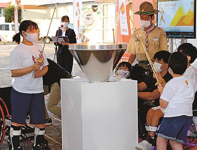 火を聖火皿に移す子どもたち＝倉吉市駄経寺町、倉吉パークスクエア