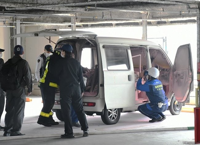 全焼した軽自動車を調べる警察官ら＝２４日午後２時２８分、松江市東朝日町