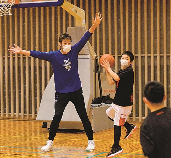 小学生と一緒にプレーしながら指導する小阪彰久選手（左）＝松江市鹿島町佐陀本郷、鹿島総合体育館