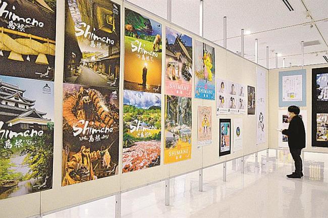 広告作品に見入る来場者＝米子市中町、市美術館