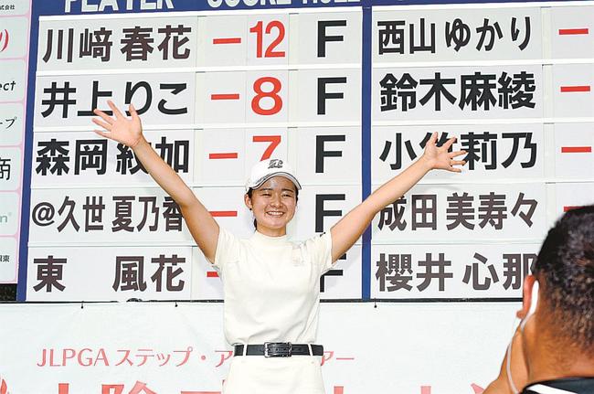 山陰ご縁むす美レディースでステップアップツアー初優勝を飾り、スコアボード前で万歳をする川崎春花選手＝２０２２年８月２６日、大山平原ゴルフクラブ
