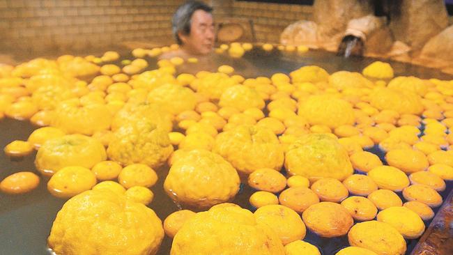 入浴客が漬かる湯船を埋めるユズ＝大田市温泉津町温泉津、薬師湯