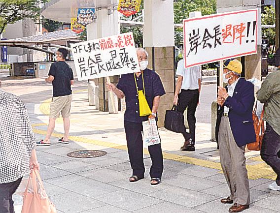 プラカードを掲げ、役員の交代を求める組合員ら＝松江市朝日町、ＪＲ松江駅前