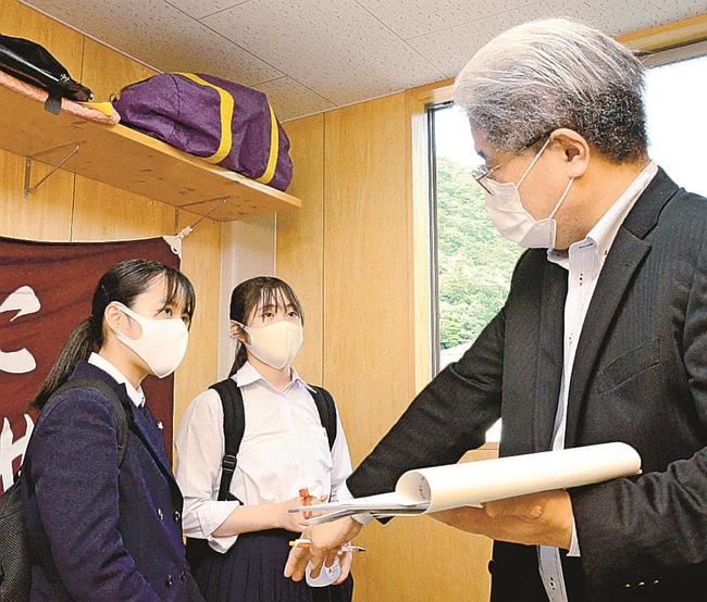 部室内で教員（右）から感染防止策の指導を受ける生徒＝鳥取市東町２丁目、鳥取西高校