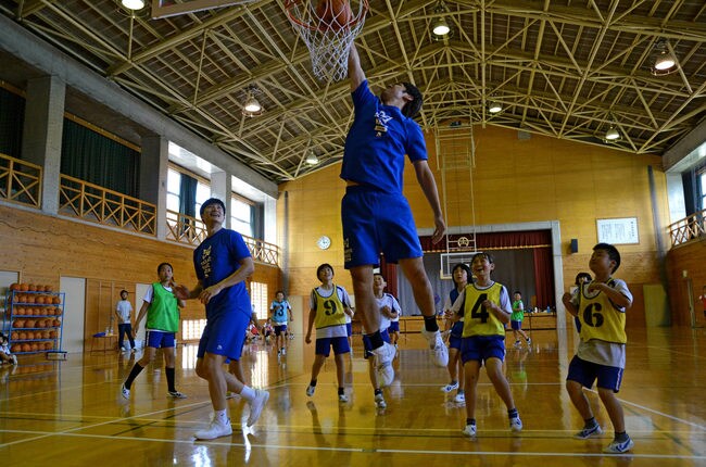 プロらしいプレーで小学生を驚かせる北川弘選手（中央）と白濱僚祐選手（左から３人目）＝島根県隠岐の島町下西、磯小学校