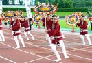 傘踊りを披露する踊り子たち＝鳥取市布勢、ヤマタスポーツパーク陸上競技場
