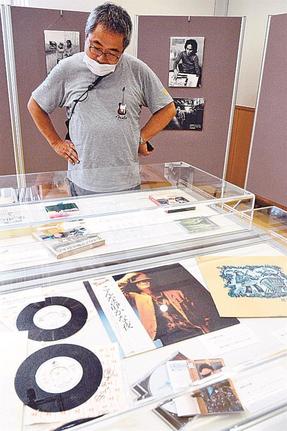 岡本おさみさんにちなむレコード盤や直筆の手紙、写真などを観賞する来館者＝米子市中町、米子市立図書館