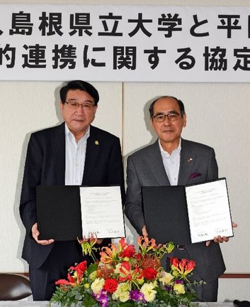 協定書を手にする清原正義理事長兼学長（左）と大谷厚郎会頭＝出雲市平田町、平田商工会議所