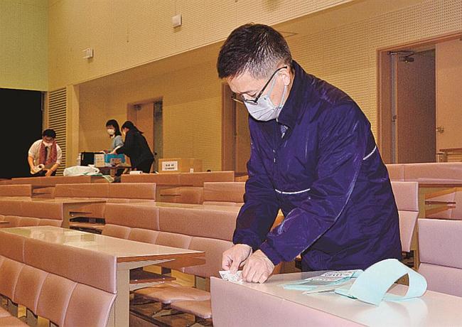 机に受験番号札を貼る大学職員＝浜田市野原町、島根県立大浜田キャンパス
