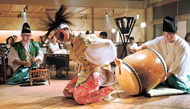 背を向けて太鼓を打つ「切部」を演じる東郷今津神楽の団員＝島根県隠岐の島町港町、隠岐プラザホテル