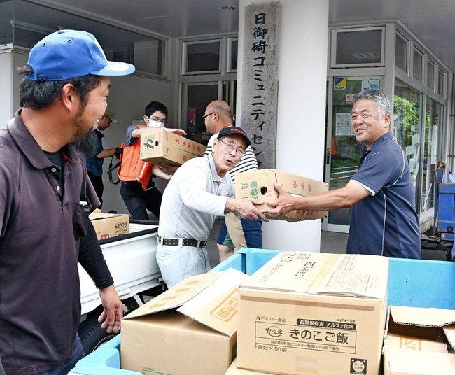 船で輸送された食料を協力して運び入れる住民＝出雲市大社町宇龍、日御碕コミュニティセンター
