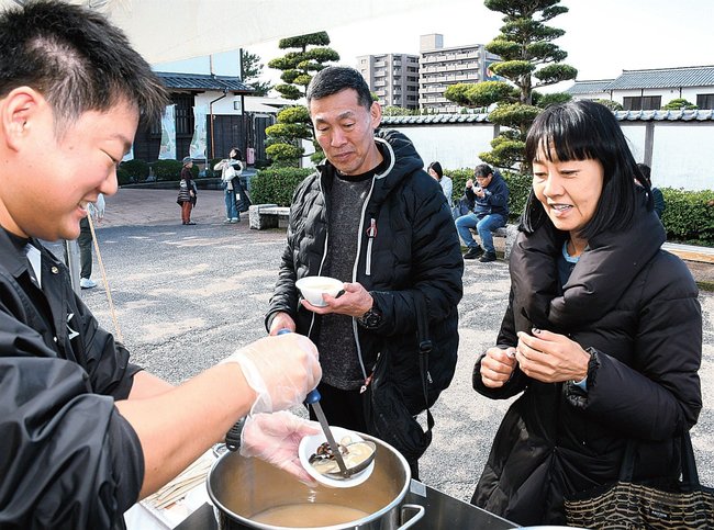 観光客にしじみ汁を振る舞う宍道湖漁協組合員(左)=松江市黒田町、ふれあい広場乗船場