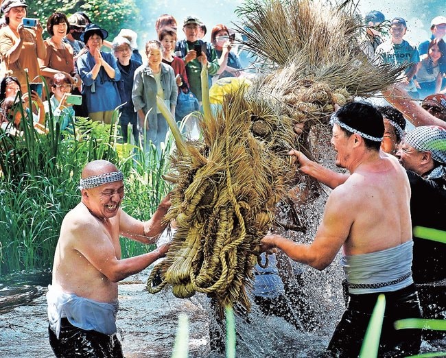 わらの竜を乱舞させる男衆＝島根県吉賀町田野原、大蛇ケ池