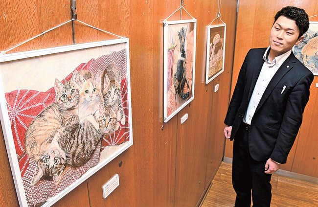 愛らしいしぐさを描いた猫の絵を楽しむ来館者＝大田市仁摩町天河内、仁摩サンドミュージアム