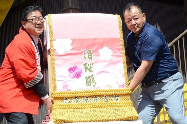 化粧まわしを披露する広田一恭市長（左）と落合勝也さん＝倉吉市明治町、打吹回廊