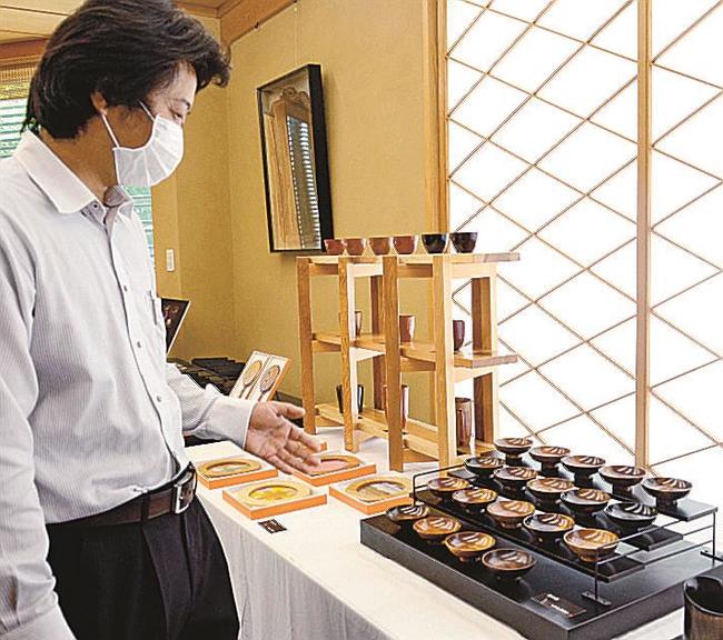 それぞれ異なる樹種で作られた盃を紹介する濱田幸介さん＝松江市天神町、彩雲堂