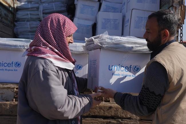 石けんや消毒液などが入った衛生キットを受け取るシリアの男性＝2月18日（提供：日本ユニセフ協会）