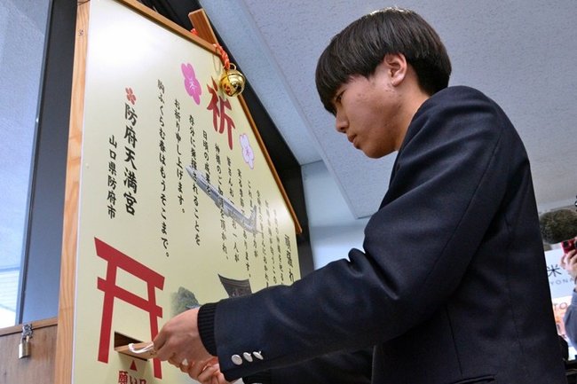 合格祈願の絵馬を投函する米子松陰高校の３年生＝境港市佐斐神町、米子空港