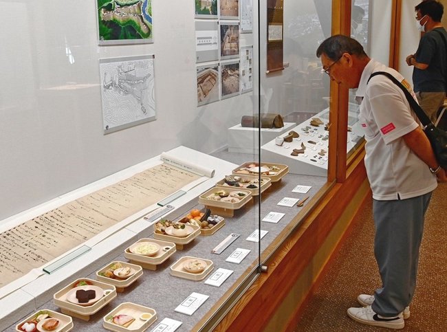 中世の食を再現した精巧なレプリカを鑑賞する来場者＝益田市本町、市立歴史文化交流館・れきしーな