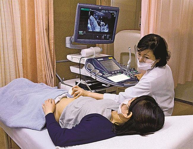 セミオープンシステムでお産を担う島根県立中央病院で、胎児の様子をエコーで確認する妊婦（手前）＝出雲市姫原町４丁目