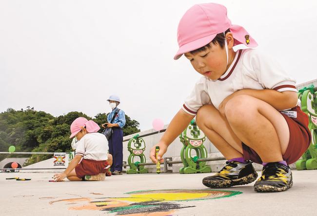 舗装前の高速道路の橋面に絵を描く園児＝出雲市湖陵町二部