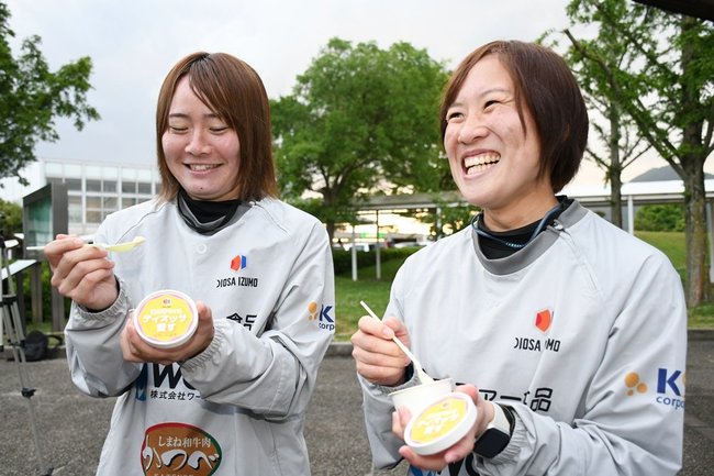 「ディオッサ愛す」を味わう柳瀬絵莉選手（左）と宮川真莉乃選手＝出雲市矢野町、出雲ドーム前