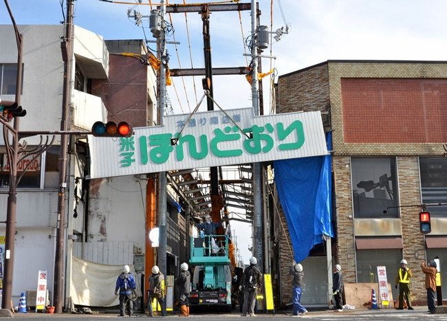 クレーンで下ろされる本通り商店街の看板＝米子市東倉吉町