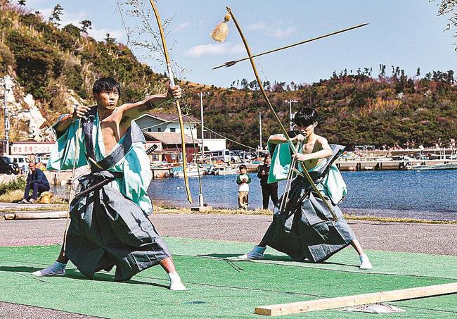 伝統の所作をこなして的を狙う小野剛さん（左）と山根蒼平さん＝島根県隠岐の島町津戸