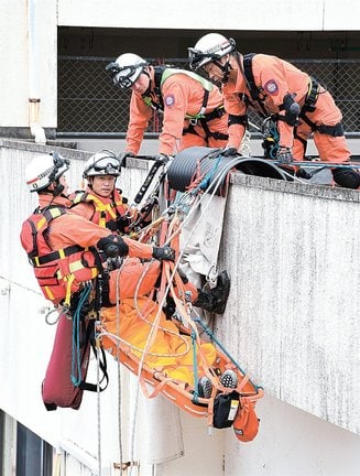 ロープを使い要救助者を引き上げる隊員＝島根県邑南町中野、公立邑智病院