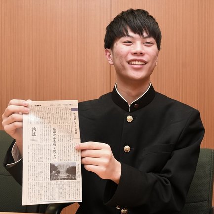 切り抜いた本紙論説を手にする山上敦也さん＝出雲市今市町、出雲高校