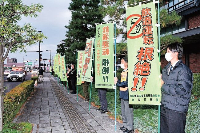 のぼりを手に、飲酒運転の根絶を呼びかける参加者=出雲市今市町、市役所前