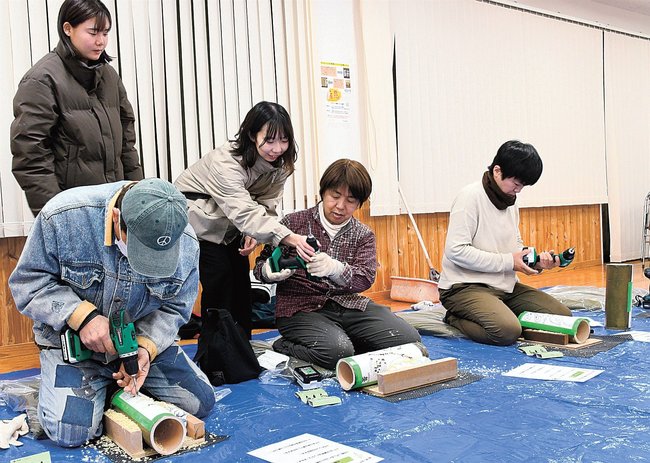 電気ドリルを使って竹明かりを作る住民=島根県海士町海士、隠岐開発総合センター
