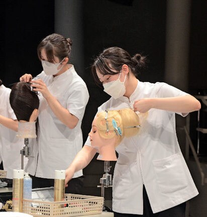 まとめ髪の部門でヘアスタイルを仕立てる参加者＝出雲市駅南町１丁目、ビッグハート出雲