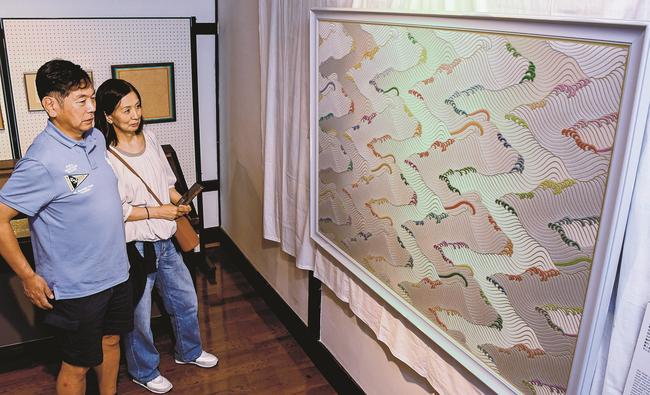 瀬戸のうちうみに見入る来館者＝大田市大森町、石見銀山資料館