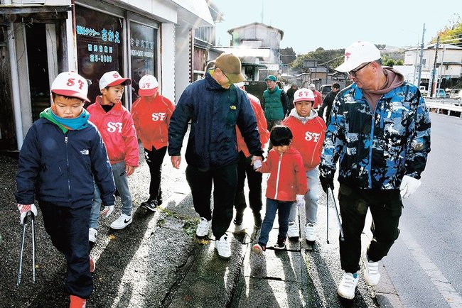 路上に目をこらしてごみを探す西郷ファイターズの選手と保護者＝島根県隠岐の島町栄町