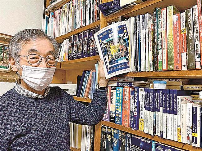 １９９８年フランス大会の公式パンフレットを手に思い出を話す坪内研二さん＝松江市宍道町宍道
