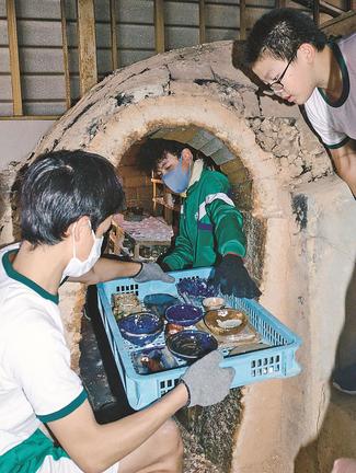 登り窯から作品を取り出す生徒=大田市水上町、大田第三中学校