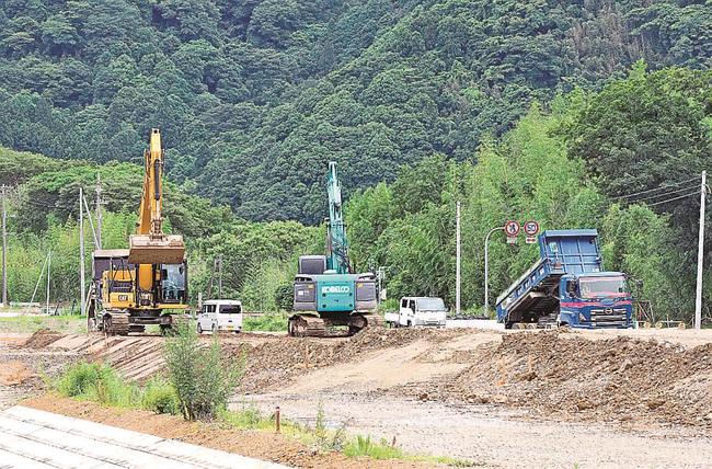 江の川沿いの堤防工事の現場。重機を使い、土を盛り固める作業が続く＝江津市松川町八神