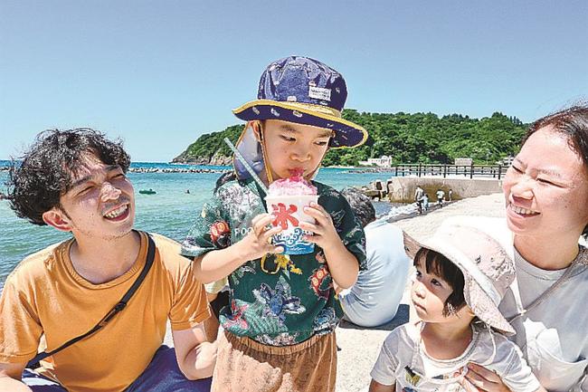 かき氷にかぶりつく子ども＝松江市島根町野波、野波海浜公園