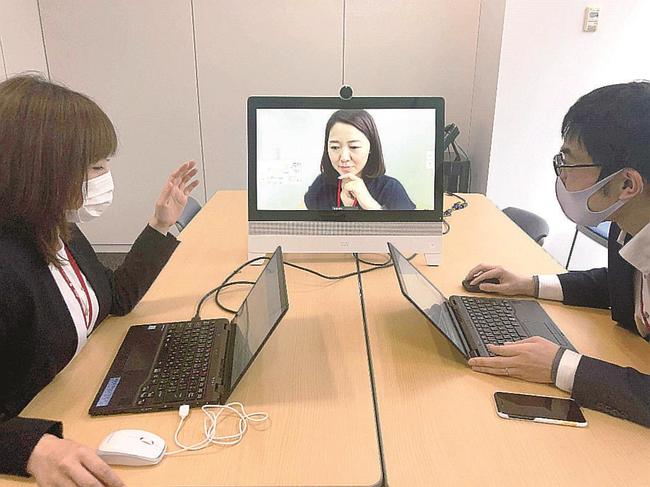 東京本社にいる社員とオンラインで打ち合わせをするＳＯＭＰＯひまわり生命保険の女性社員（中央）＝５月、東京都新宿区（同社提供）