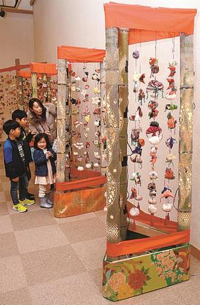 華やかなつるし飾りと竹灯籠の作品を楽しむ来館者＝出雲市浜町、出雲文化伝承館