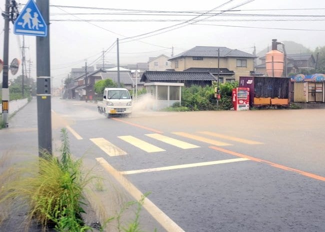 大雨の影響で冠水した道路＝１３日午前１０時３１分、鳥取市福部町