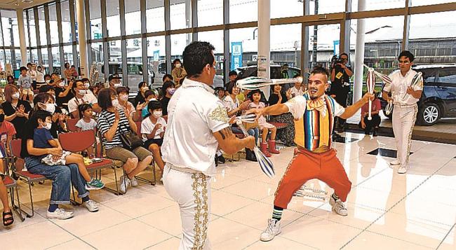 息の合ったジャグリングで店内の家族連れを沸かせるアポロブラザーズ＝松江市東津田町、ホンダカーズ松江東津田店