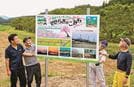 案内看板を設置する祖式町元気なまちづくりの会のメンバー＝大田市祖式町