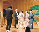 能舞台で成人を祝い、両親と写真に納まる野口紗那さん(中央左)と怜那さん(同右)=8月、東京・銀座