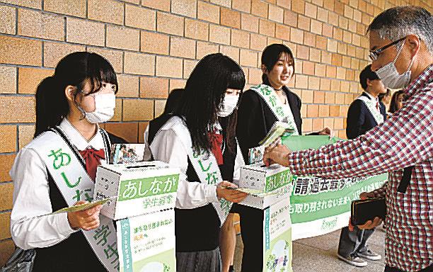 通行者（右）から募金を受け取る高校生＝松江市朝日町、ＪＲ松江駅北口