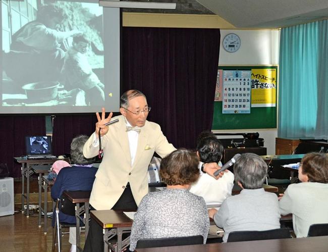 昔の写真を使ってお年寄りに回想法を実践する鈴木正典さん（左）＝２０１７年、倉吉市内